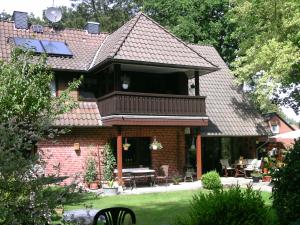 een bakstenen huis met een balkon en een patio bij Ferienwohnung Neumair in Undeloh