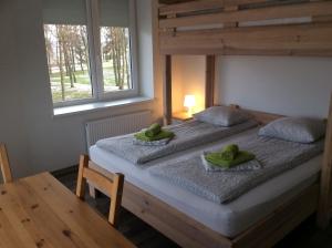 2 Betten in einem Zimmer mit zwei grünen Handtüchern darauf in der Unterkunft BHB Hotel in Marijampolė