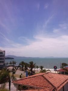 vistas a una playa con un edificio y al océano en Pousada Vó Regina, en Florianópolis