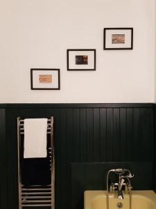 a bathroom with a sink and three pictures on the wall at Albert Street Apartment in Kirkwall