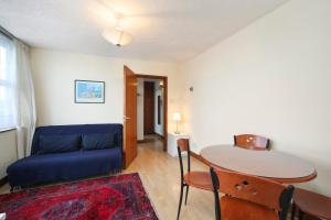 a living room with a blue couch and a table at 202 Apartments in London