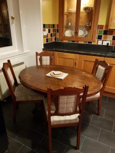 a wooden table and chairs in a kitchen at Albert Street Apartment in Kirkwall