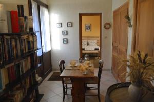 a dining room with a table and a room with a bed at Le Domaine in Les Iffs