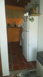 a kitchen with a white refrigerator and a tile floor at Shalom in Mina Clavero
