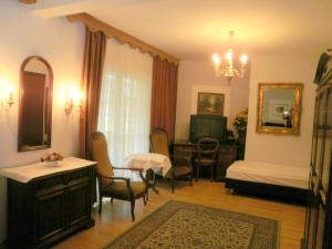 a living room with a bed and a table and chairs at Gästehaus Auerhahn in Vöcklabruck