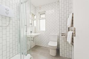 La salle de bains blanche est pourvue de toilettes et d'un lavabo. dans l'établissement Temple Bar Crown Square Apartments, à Dublin