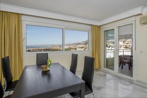 a dining room with a table and a large window at Frente al mar in Benalmádena