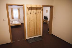 ジェレズナー・ルダにあるPenzion Alpský Důmの木製のドアとデスクが備わる空き部屋