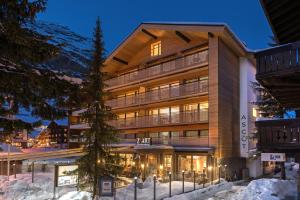 采爾馬特的住宿－Haus-Ascot-Zermatt，一座大建筑物,在晚上下雪