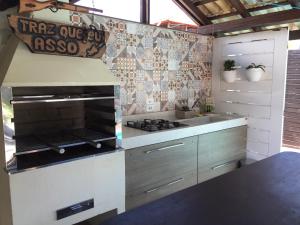 a kitchen with a stove top oven in a kitchen at Casa para temporada in Florianópolis