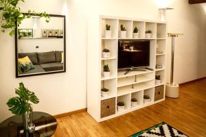 BDC_38Apartment في بارما: غرفة معيشة مع رف كتاب أبيض مع نباتات الفخار