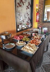 un buffet con muchos platos de comida en una mesa en Recanto do Mergulhão, en Maceió