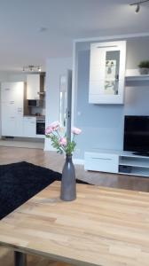 eine Vase mit rosa Blumen auf einem Tisch im Wohnzimmer in der Unterkunft Ferienwohnung mit Loggia in Münster