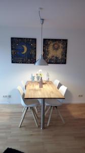 Ferienwohnung mit Loggia في مونستر: طاولة خشبية مع كراسي بيضاء في الغرفة