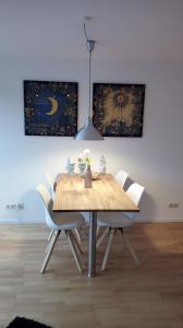 una mesa de madera con sillas blancas en una habitación en Ferienwohnung mit Loggia en Münster