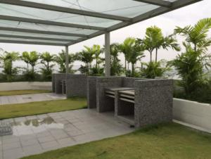 a patio with a table and some palm trees at Damaye Evo Soho Suites in Central Bangi in Kampong Sungai Ramal Dalam