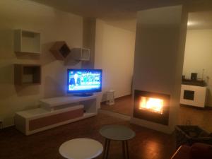 a living room with a fireplace and a television at Monte Loureiro-caveira in Melides