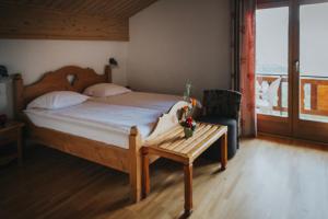 a bedroom with a bed and a chair and a table at Hôtel Magrappé in Veysonnaz