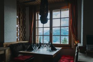 a room with a table, chairs, and a window at Hôtel Magrappé - Like At Home in Veysonnaz
