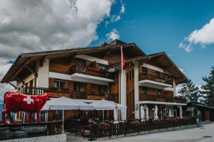 a building with a cow statue in front of it at Hôtel Magrappé in Veysonnaz