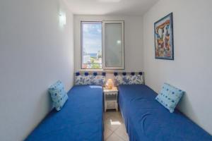 una camera con due letti e una finestra di Deliziosi Appartamenti Sul Mare a Leuca