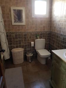 een badkamer met een toilet, een wastafel en een raam bij Villa - zeezicht, zwembad in Nerja