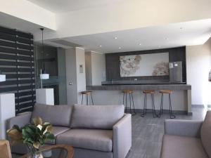 sala de estar con sofá y bar con taburetes en Costa Horizonte 2, en Concón