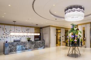 a lobby with a reception desk and flowers on a table at Braira Al Wezarat in Riyadh