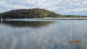 una gran masa de agua con una montaña en el fondo en Motel Farnboro, en Narooma