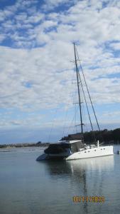 a sailboat is docked in a body of water at Motel Farnboro in Narooma
