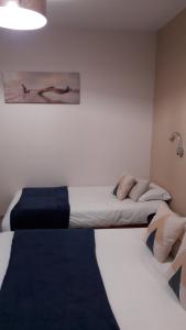 - 2 lits dans une petite chambre avec 2 jupes de lit dans l'établissement L'Oustal, à Naves