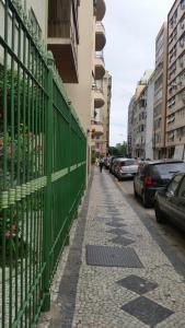 une clôture verte à côté d'une rue avec des voitures garées dans l'établissement Stúdio no Flamengo, à Rio de Janeiro