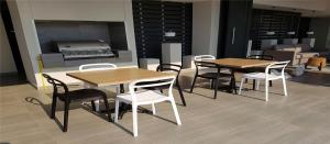 Una habitación con dos mesas y sillas y una parrilla. en Costa Horizonte 2, en Concón