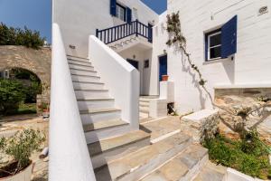 uma escada que leva a uma casa branca com portas azuis em PURE WHITE 1BD house with amazing Sea Views in Naousa em Naousa