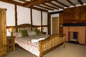 1 dormitorio con cama de madera y chimenea en The Three Gables en Stratford-upon-Avon