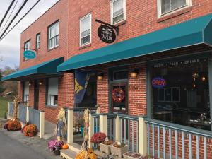 un restaurante con un edificio de ladrillo con toldo azul en The Escape, en Lewisburg