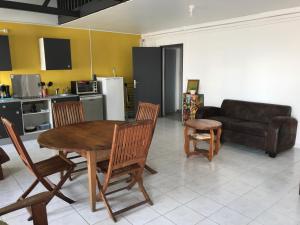a living room with a table and chairs and a couch at appart coeur de rhum in Pointe-à-Pitre