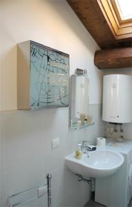 a white bathroom with a sink and a mirror at Appartamenti Ricasoli51 in Florence