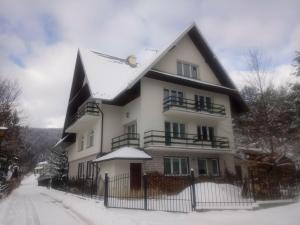 a white house with snow on the roof at Dom "Honorat", Kamianna 70, 33-336 in Kamianna