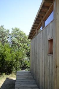 a wooden walkway leading to a wooden building at La Casita del Puente in La Pedrera +4 photos