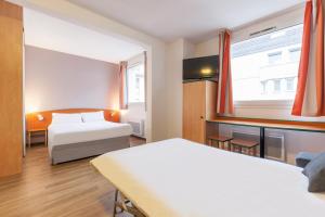 a hotel room with two beds and a window at City Residence Access Strasbourg in Strasbourg