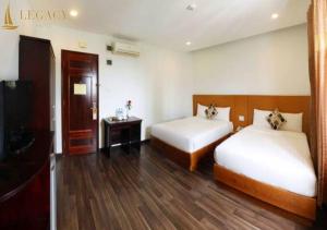 Un pat sau paturi într-o cameră la Legacy Hotel