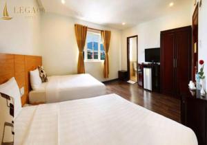 Un pat sau paturi într-o cameră la Legacy Hotel
