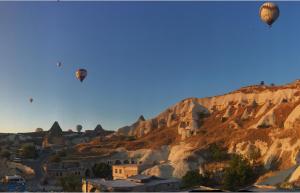 three hot air balloons flying over a mountain at Mosaic Cave Hotel in Göreme