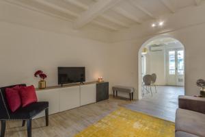 フィレンツェにあるApartments Florence - Chiara Stylishの白い壁のリビングルーム(テレビ付)
