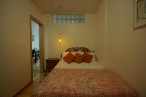Un dormitorio con una cama con almohadas naranjas. en My Mouraria Suites, en Lisboa