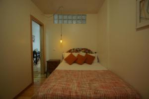 リスボンにあるMy Mouraria Suitesのベッドルーム1室(オレンジ色の枕が付いたベッド1台付)