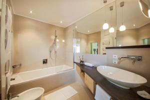 a bathroom with a sink and a tub and a toilet at Garni La Majon in Selva di Val Gardena