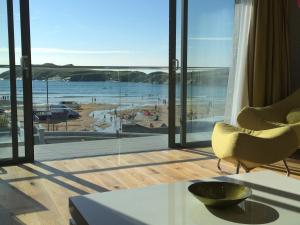 a living room with a view of a beach at 9 Sandpiper Cottages in Newquay