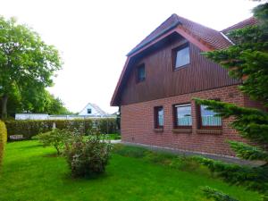 a red brick house with a green yard at Ferienwohnung am Borgwallsee in Steinhagen